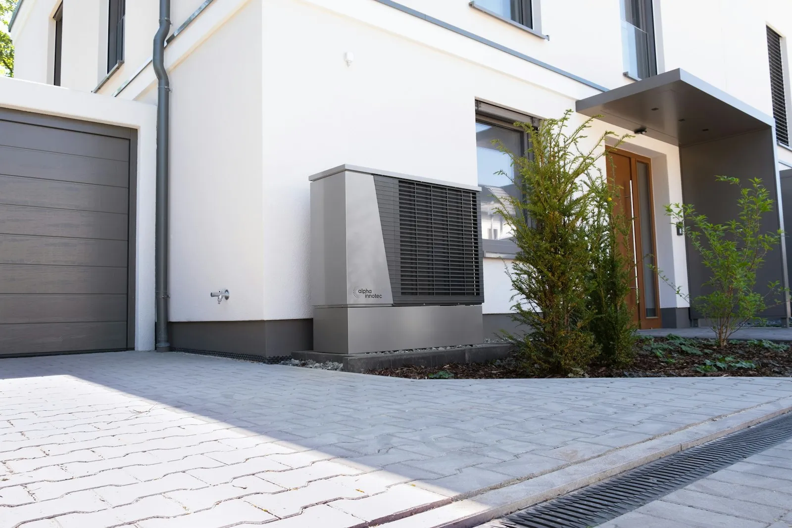 Modern heat pump unit installed beside a home on a mounting pad