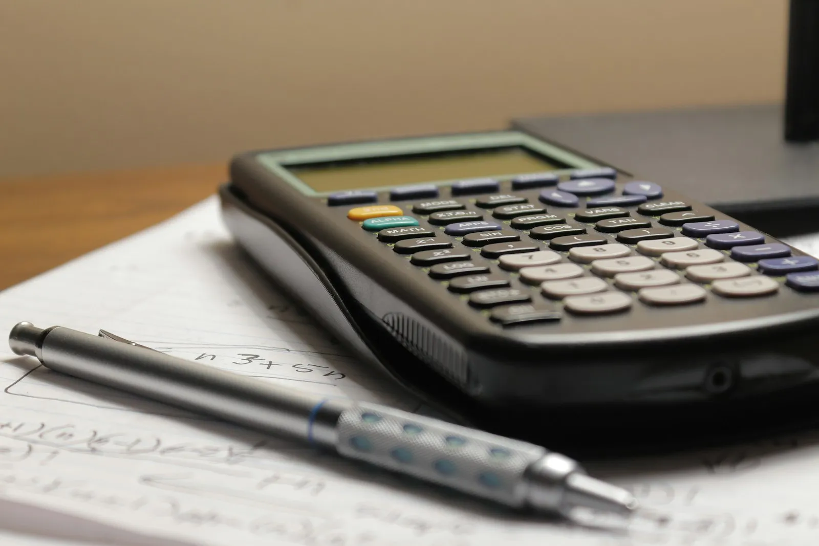 Homeowner reviewing paperwork and a calculator at a kitchen table