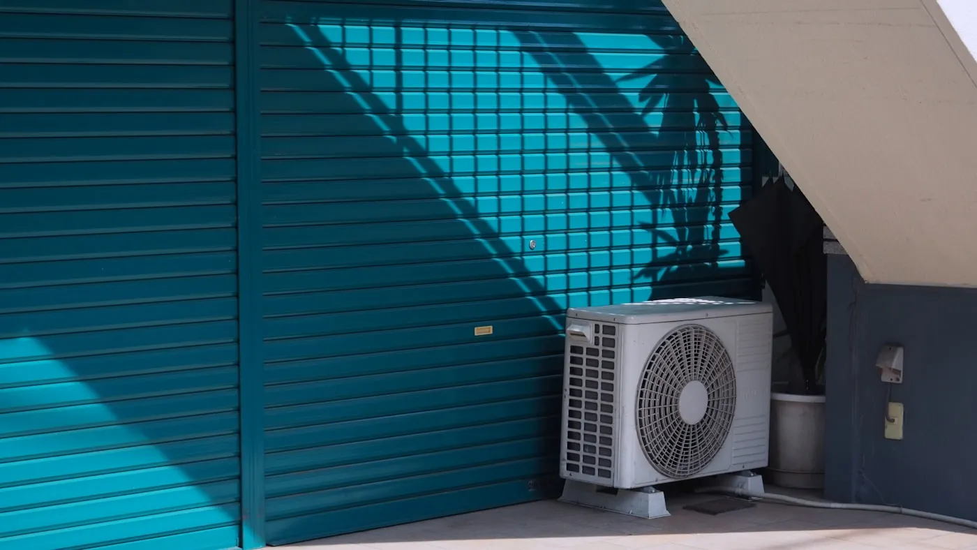Technician commissioning a new outdoor condenser unit with gauges